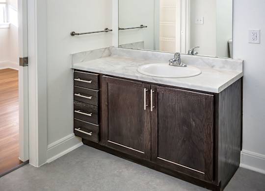 A bathroom with a sink, mirror, and lights.