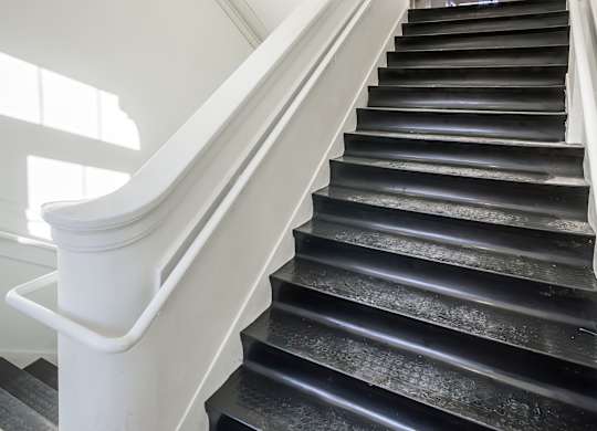 A staircase with black steps and white railings.