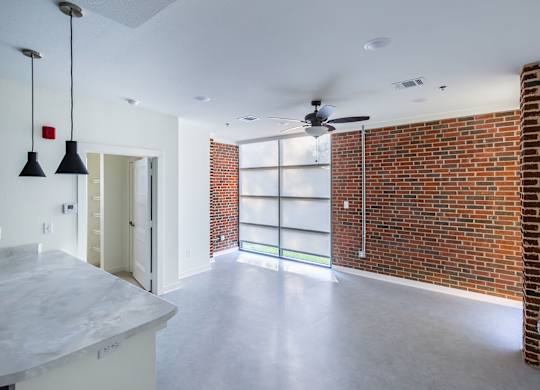 A room with a brick wall and a ceiling fan.