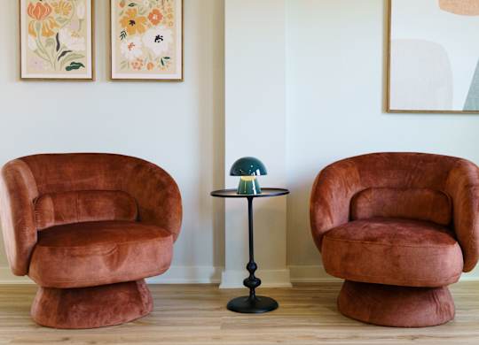 Two brown chairs and a table in a room.