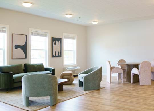 A living room with a green chair and a white sofa.