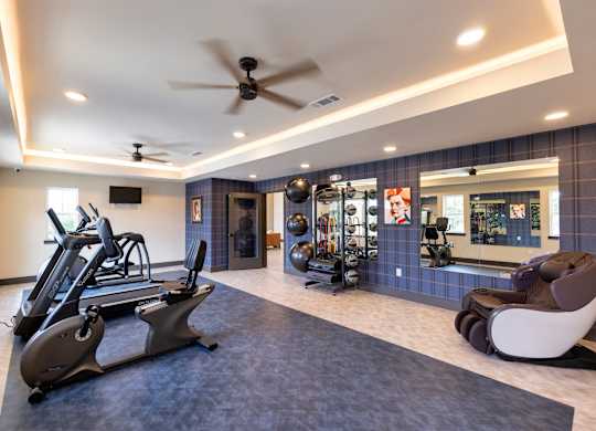 A spacious gym with a treadmill, exercise balls, and a mirror.