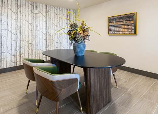 A dining room with a round table and chairs.