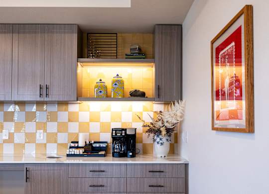 A kitchen with wooden floors and a checkered backsplash.