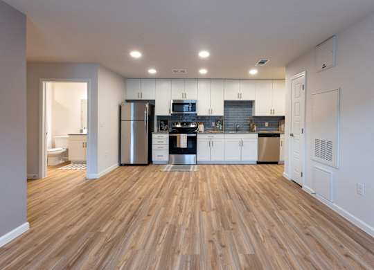 A kitchen with wooden floors and white walls.
