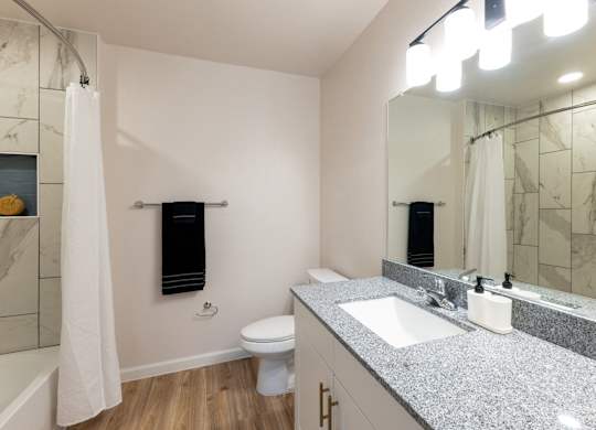 A bathroom with a toilet, sink, and shower.