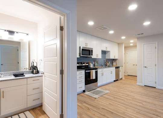 A kitchen with white cabinets and a wooden floor.