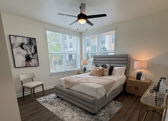 A bedroom with a large bed and a ceiling fan.