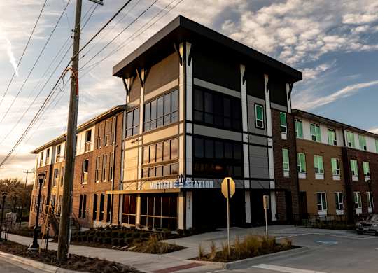A large building with a sign that says "Hillcrest Apartments" on it.