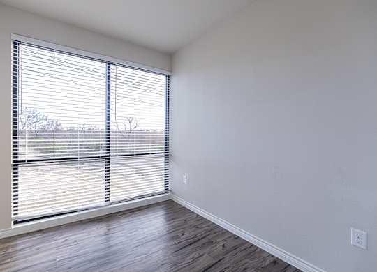 A room with a window covered by blinds.