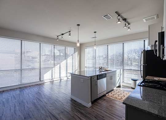 A modern kitchen with wooden floors and white walls.