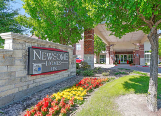 The entrance to Newsome Homes is framed by a beautiful flower bed.