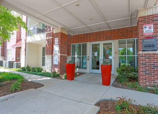 The entrance to a building with a brick wall and glass doors.