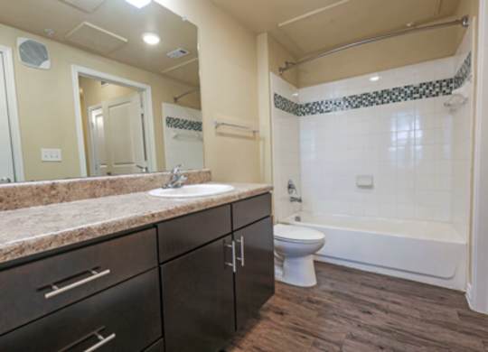 A bathroom with a sink, toilet, and bathtub.