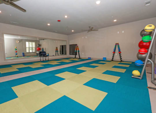 A room with a blue and yellow tiled floor and a mirror on the wall.