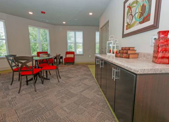 A kitchen with a table and chairs in front of a window.