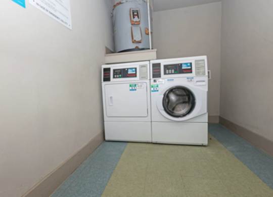 A white washing machine and dryer in a small room.