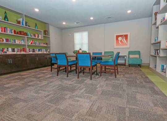 A room with a carpeted floor and a bookshelf filled with books.