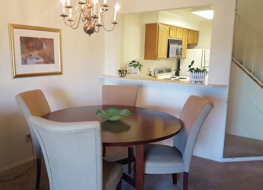 A dining room with a table and chairs.