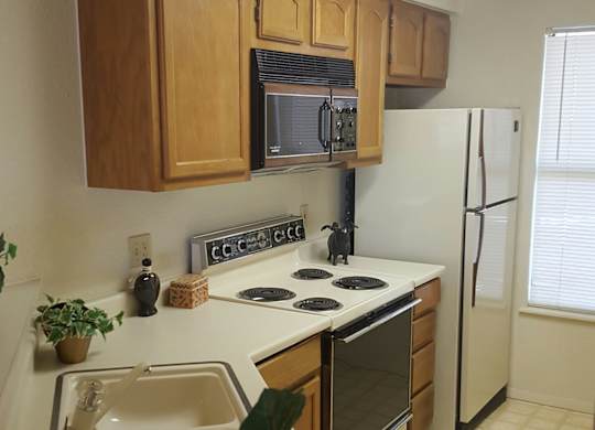 A kitchen with a white fridge and wooden cabinets.
