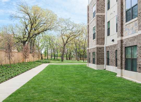A grassy area in front of a brick building.