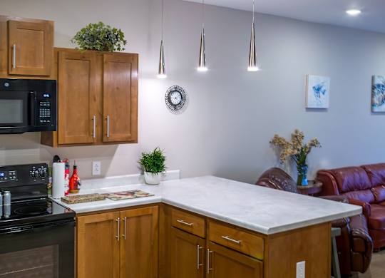 A kitchen with wooden cabinets and a black stove top oven.