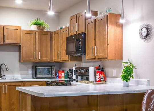 A kitchen with a bar stool and a chair.
