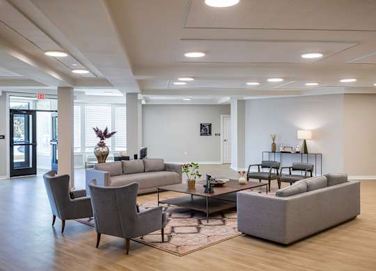 A spacious living room with a grey sofa set and a coffee table.
