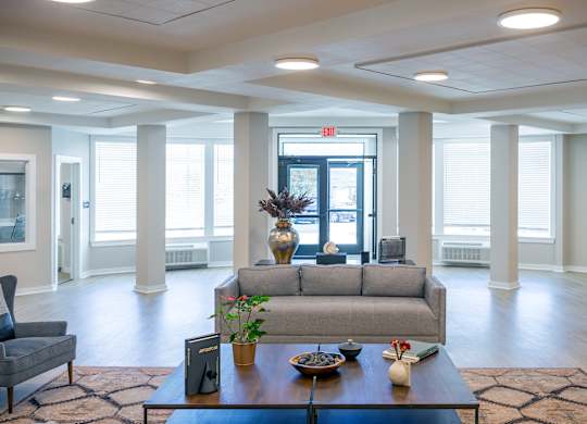 A living room with a grey couch, a coffee table, and a chair.