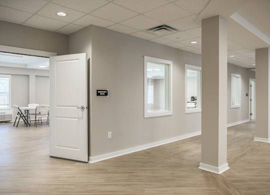 A room with a white door and a dining table with chairs.