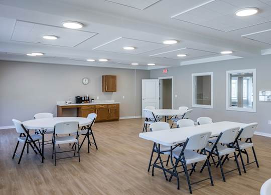 A white table with chairs is set up in a room with a wooden floor.
