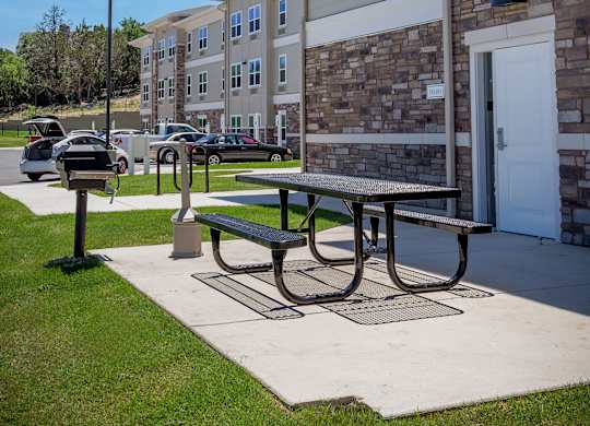 A sunny day at a residential complex with a picnic table in the foreground.