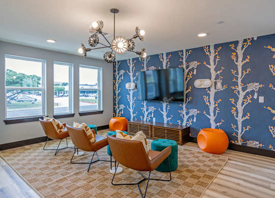 A room with a blue wallpaper and a wall-mounted television.