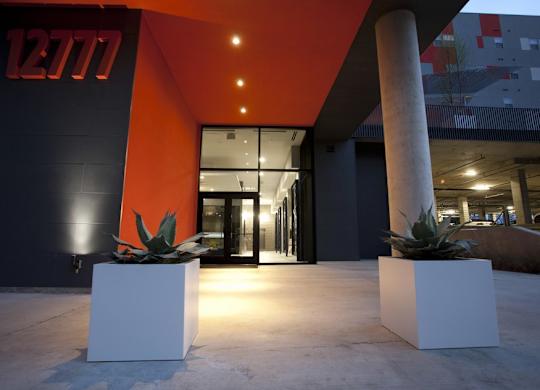 A modern building with a red and black color scheme and a glass door.