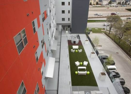 A red building with a green lawn in front.