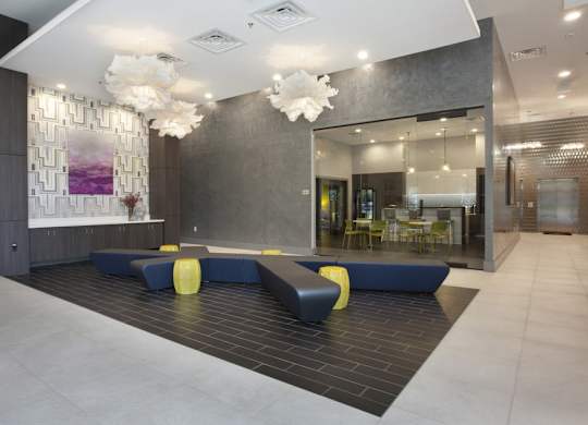 A modern lobby with a reception desk and a large abstract painting on the wall.