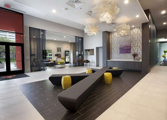A modern hallway with a bench and a chandelier.
