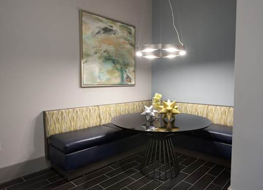 A round table with a gold star on it is in the middle of a room with a painting hanging on the wall.