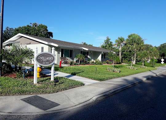 A sign for Villages at Peterson Park is on the corner of a street.