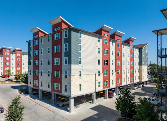 A large apartment complex with red and grey buildings.