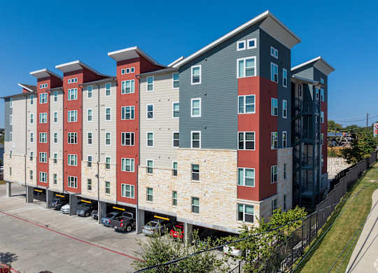 A large apartment complex with red and grey buildings.