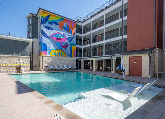 A pool with a white fountain in the middle of it.