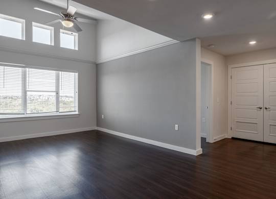 A room with a ceiling fan and wooden flooring.