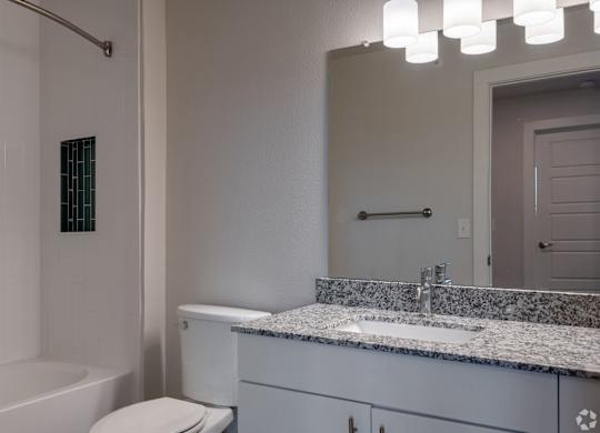 A white bathroom with a tub, toilet, and sink.