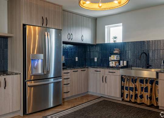 A modern kitchen with a stainless steel refrigerator and wooden cabinets.