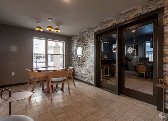 A room with a stone wall and a table with chairs.
