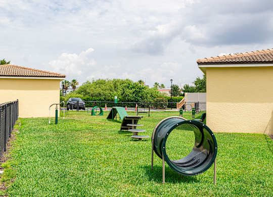 A playground with a green slide and picnic table.