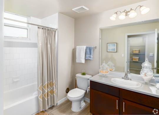 A white bathroom with a toilet, sink, and shower.