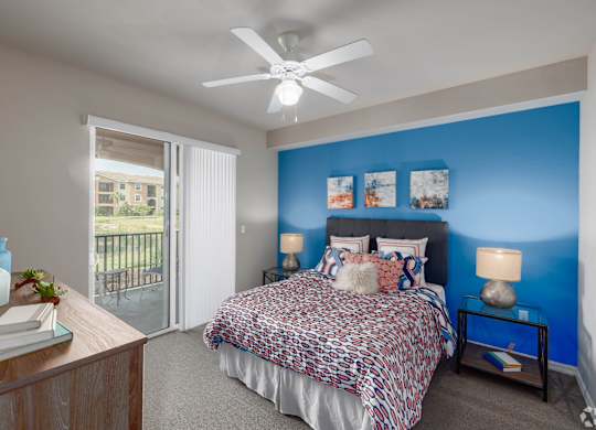 A bedroom with a bed, nightstands, and a ceiling fan.