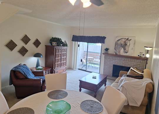 A living room with a fireplace and a dining table.